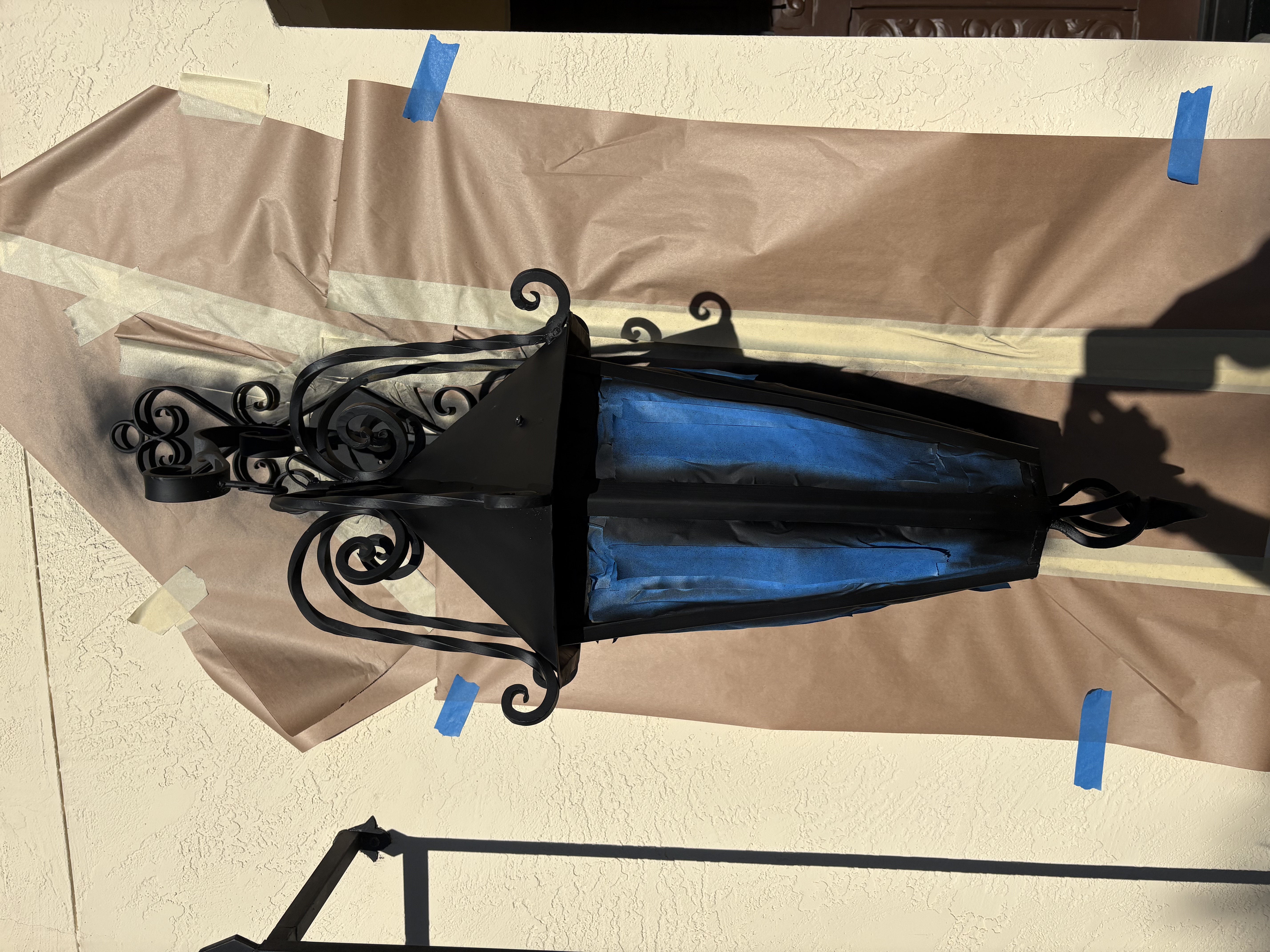 Exterior wall-mount lantern being refinished and painted